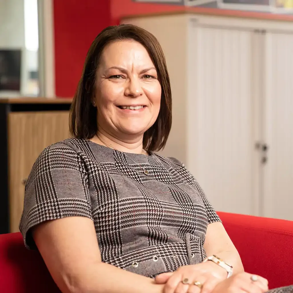 Professional profile picture of a business woman in a commercial environment.