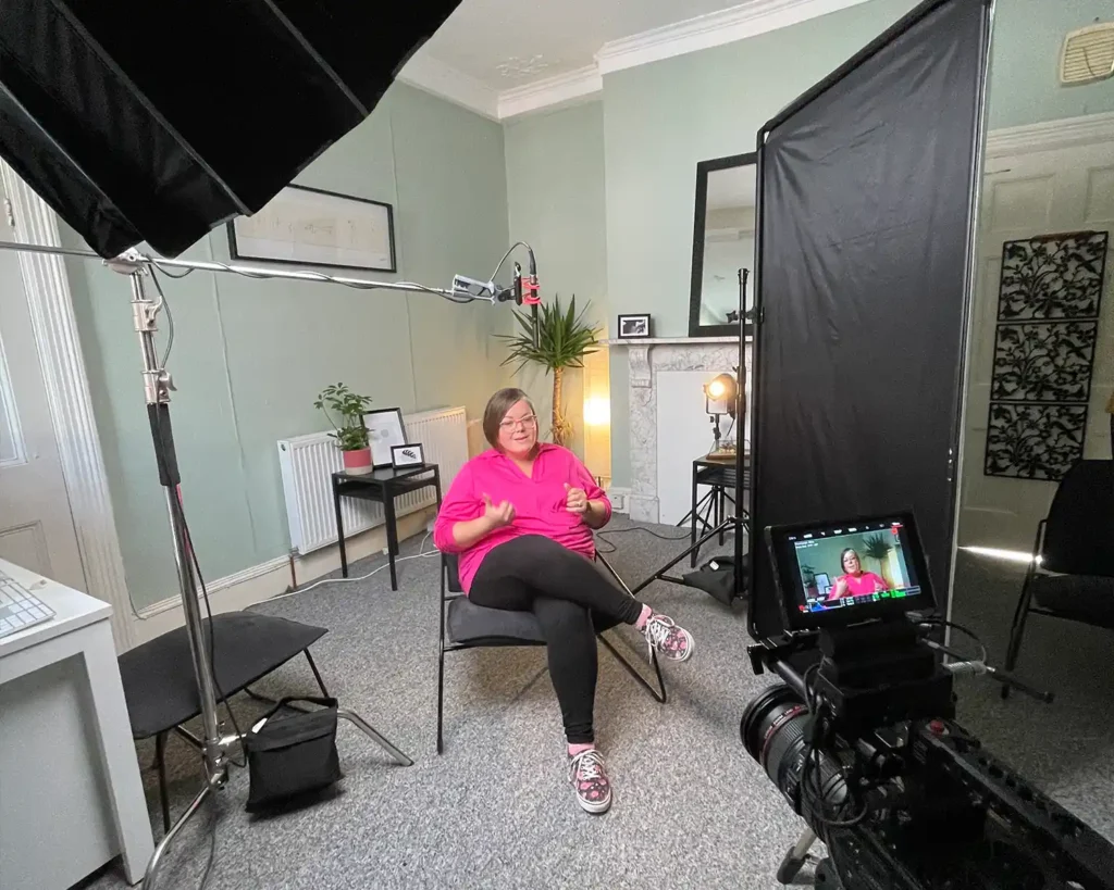 Behind the scenes photograph of filming video content for a charity, featuring high end lighting, cameras and audio equipment