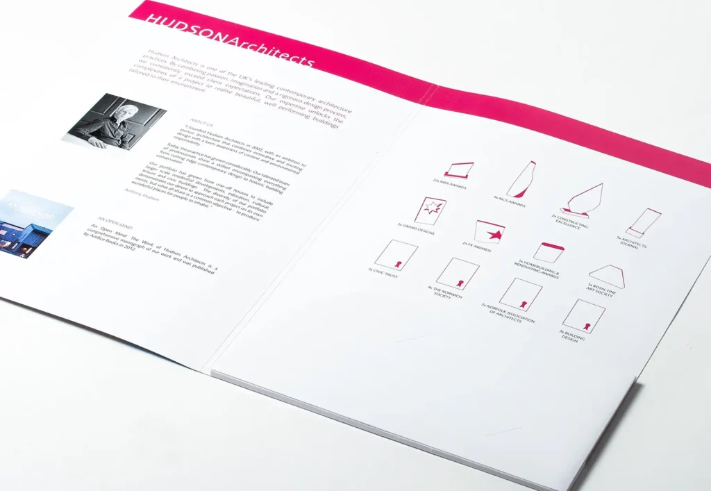 Photograph of the inside of the cover, showing text and pink illustrations of each award the practice has received.