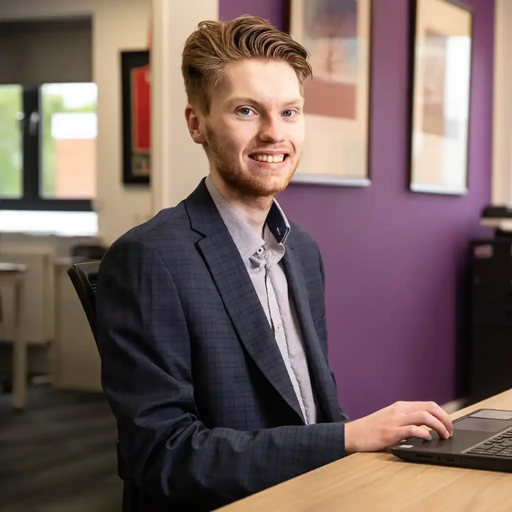 Photograph of a young business man in an office environment.