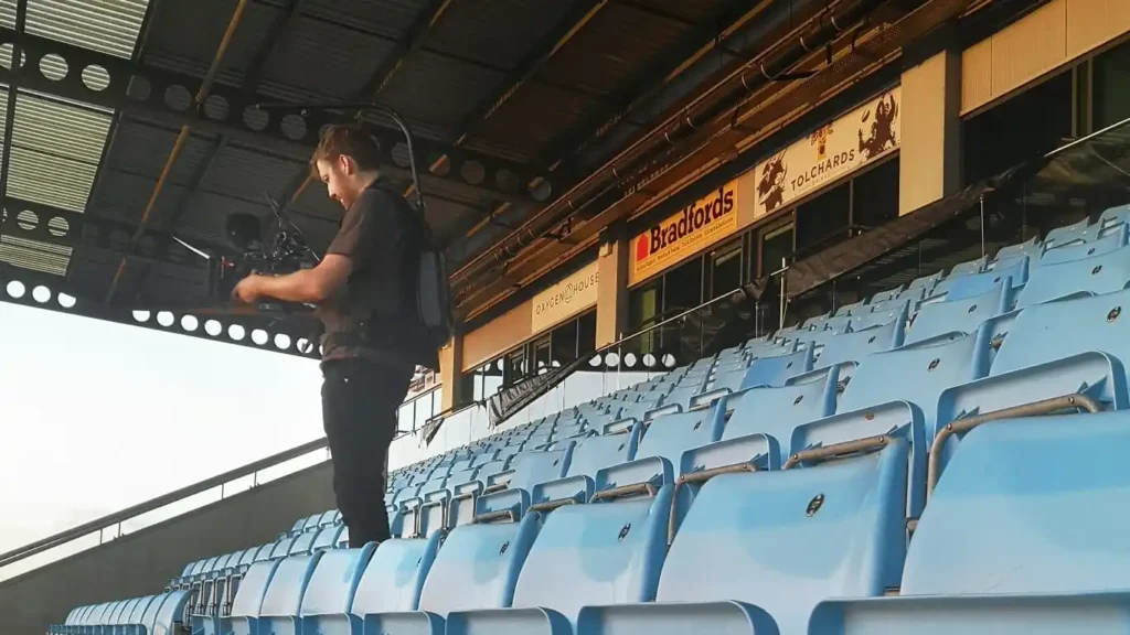 Photograph of James Bussey, founder of MADE BY WOODSMOKE filming at the Exeter Chiefs Rugby Stadium