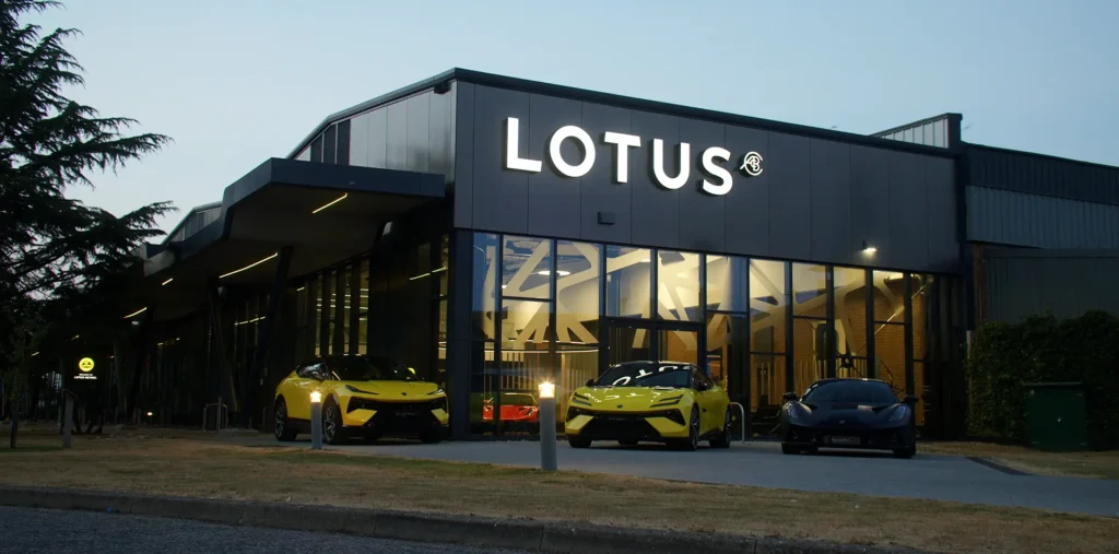 Banner image for MADE BY WOODSMOKE featuring the Lotus Cars factory with high performance cars in front.