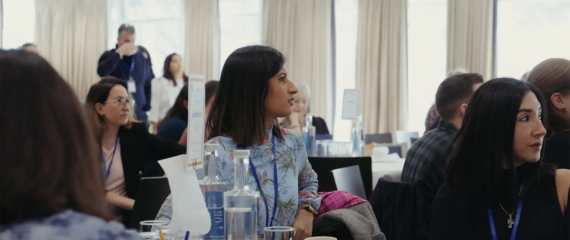Still frame from an event video featuring a business woman in smart clothing at a conference